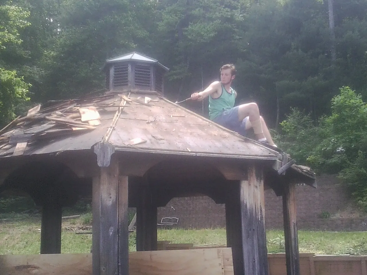 Tearing the old roof off a wooden gazebo before new shakes in Hamilton
